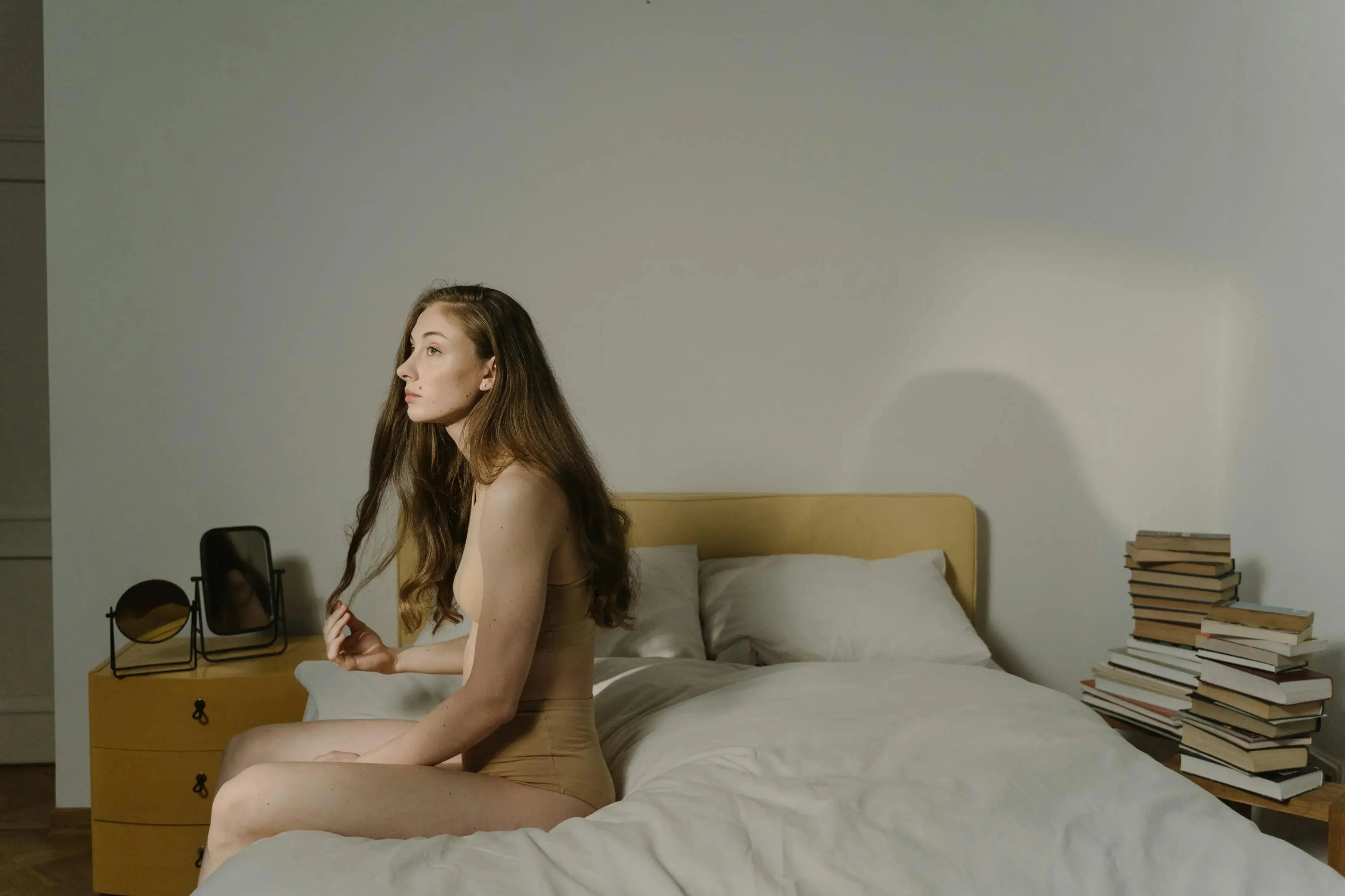 Banner image for SHEVEREIGN blog Her Turning Point, featuring a woman sitting on her bed in soft light, symbolising self-discovery, awakening, and feminine empowerment