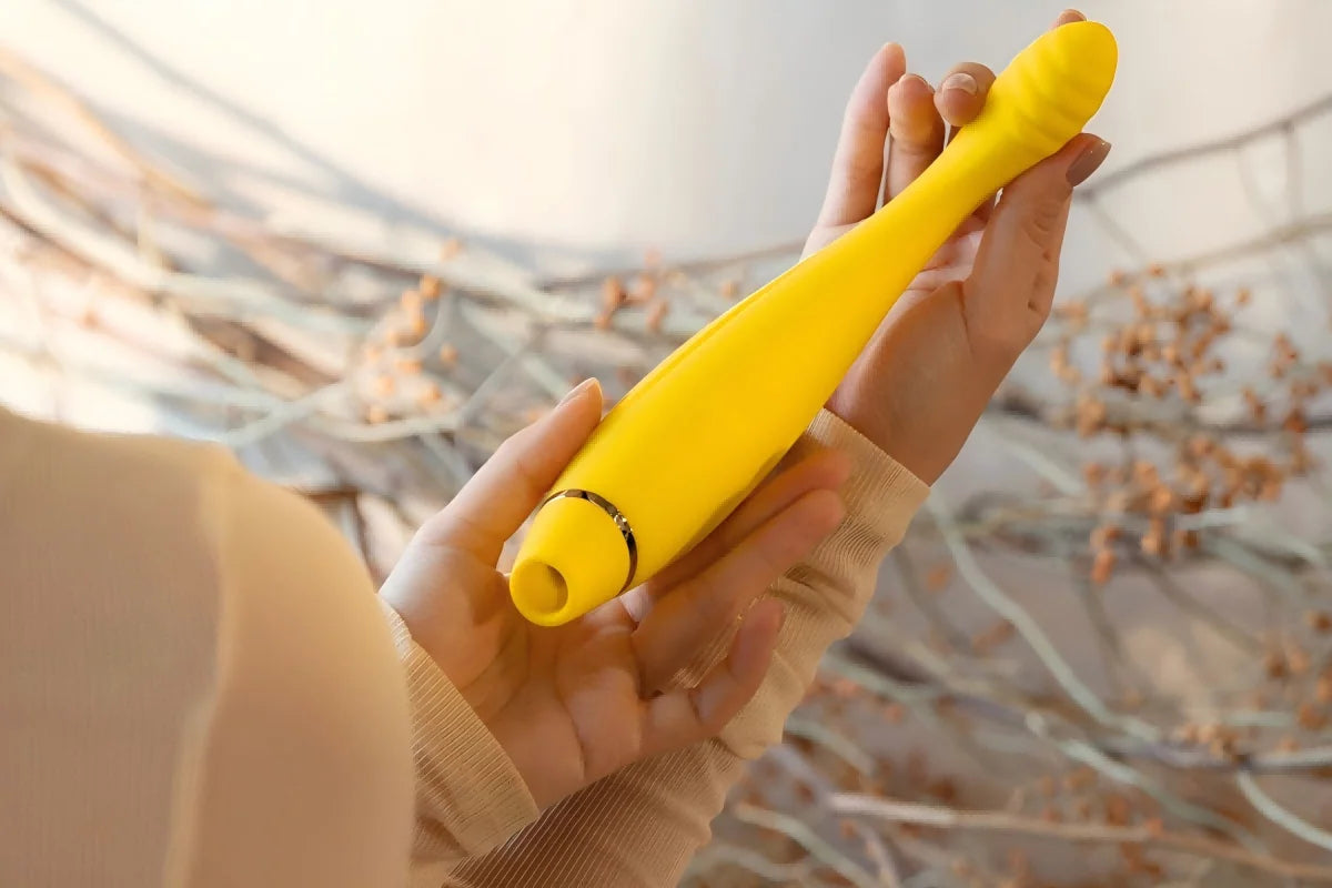 SHEVEREIGN Fusion Bliss g spot vibrator product detail showing the golden curved design in hand, highlighting its ergonomic silhouette, vibration and suction features, and refined intimate elegance