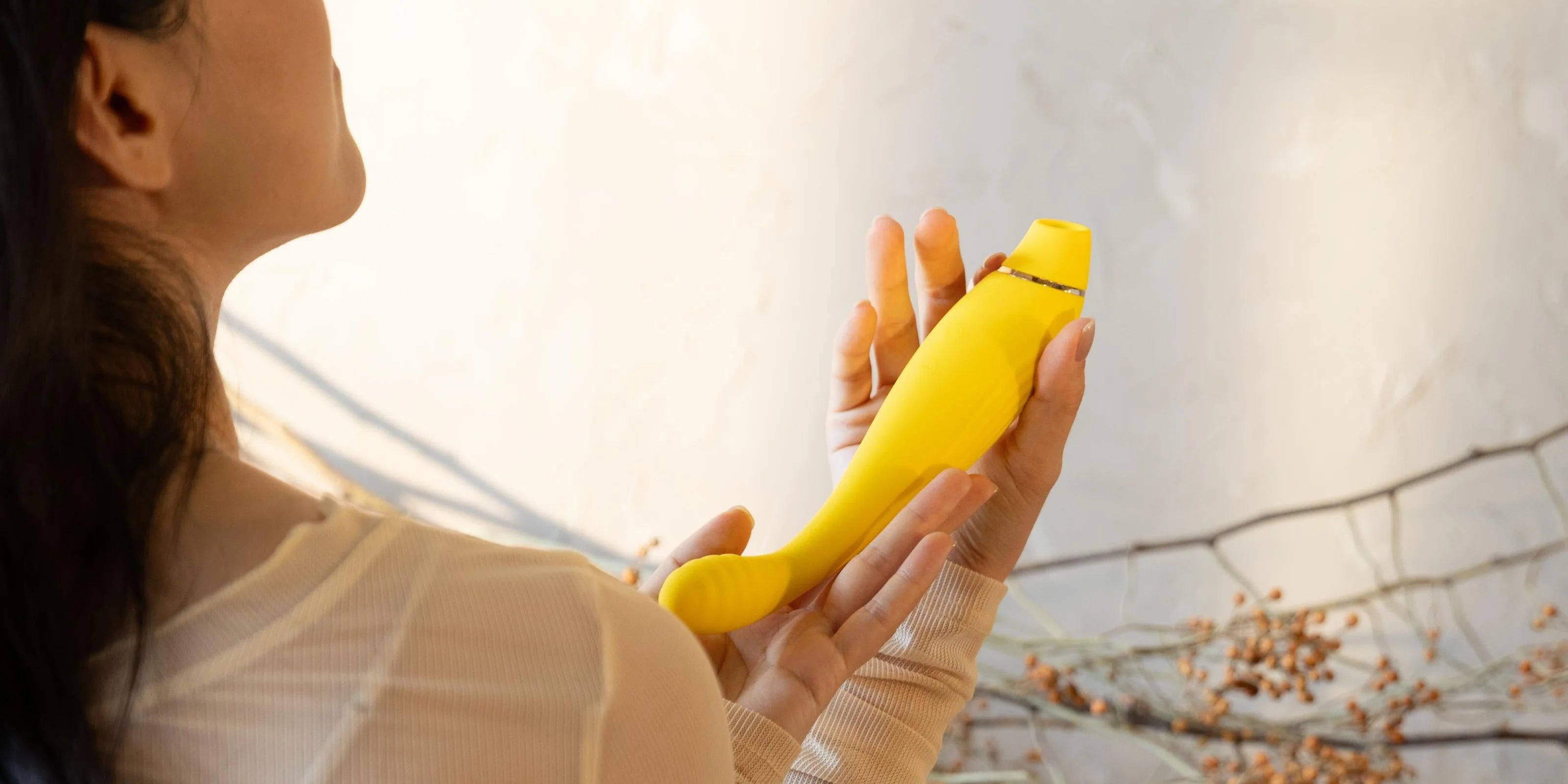 SHEVEREIGN Fusion Bliss g spot vibrator video cover featuring the golden curved design held in warm daylight, highlighting its dual zone silhouette and modern intimate elegance