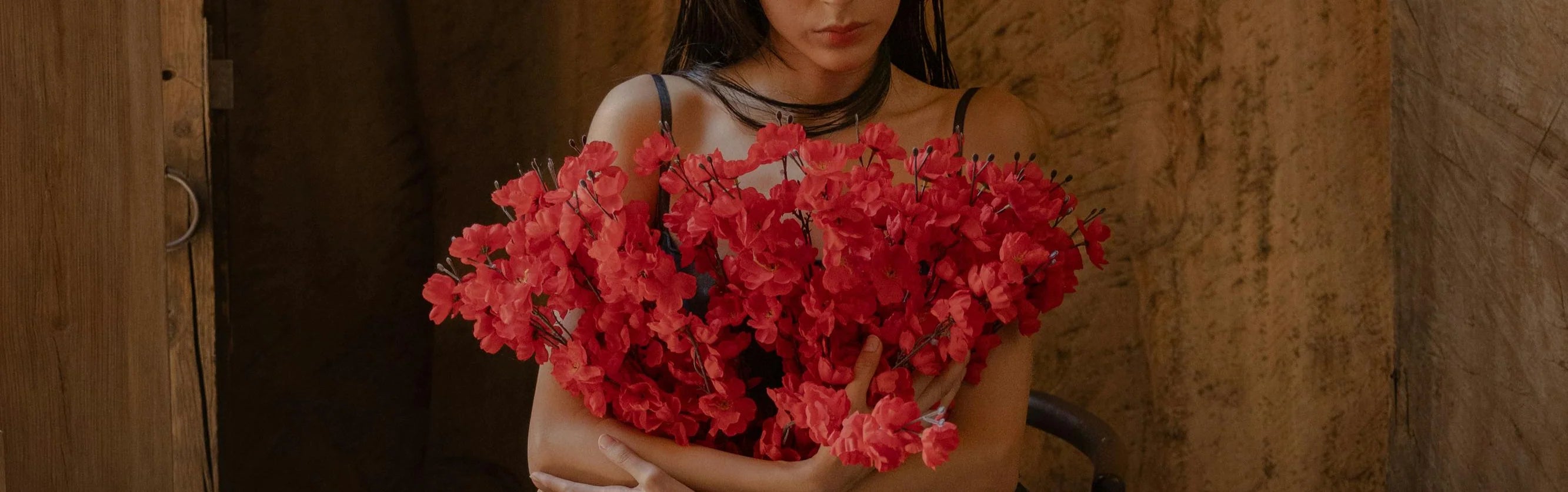 SHEVEREIGN woman holding red flowers, symbolizing confidence, femininity, and self-expression in the brand’s newsletter invitation